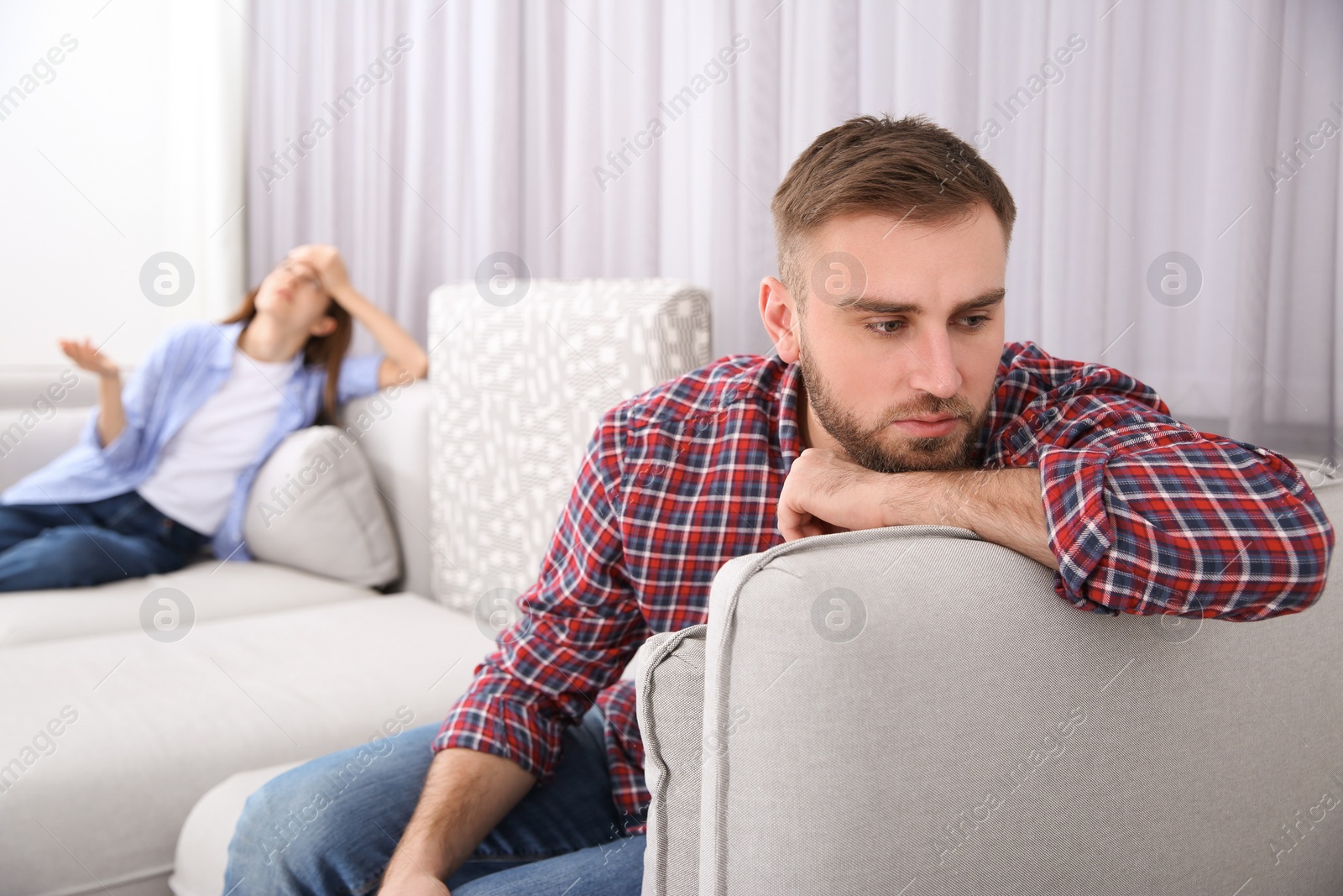 Photo of Unhappy man after quarrel with his girlfriend indoors. Relationship problems