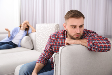 Photo of Unhappy man after quarrel with his girlfriend indoors. Relationship problems