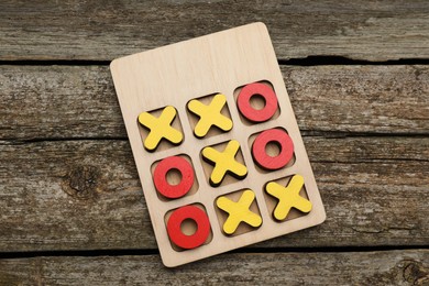 Tic tac toe set on wooden table, top view