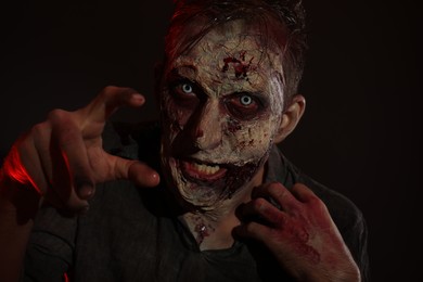 Photo of Scary zombie on dark background. Halloween monster