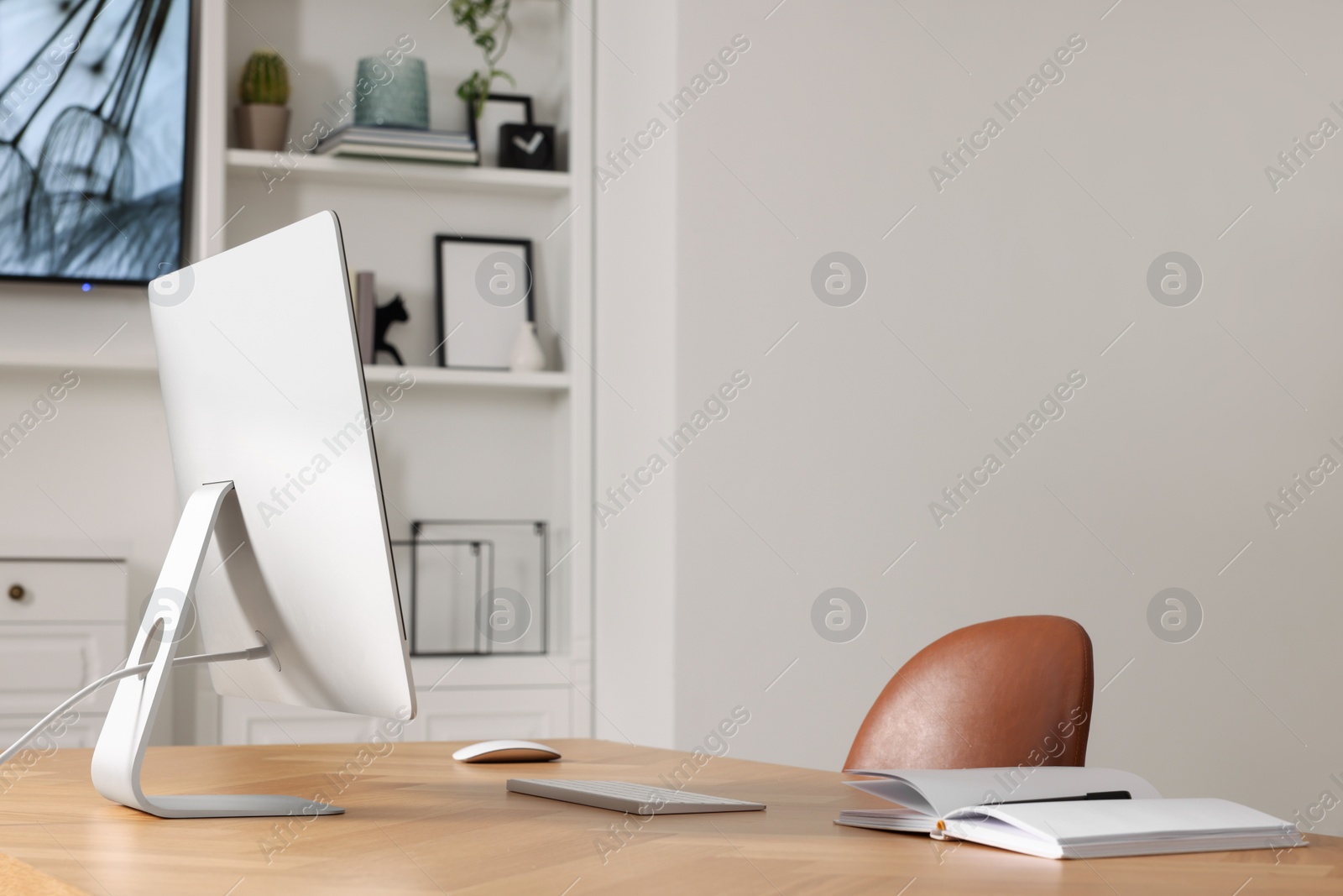 Photo of Interior design. Cosy workplace with computer near tv area. Space for text