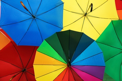 Photo of Many stylish colorful umbrellas as background, closeup