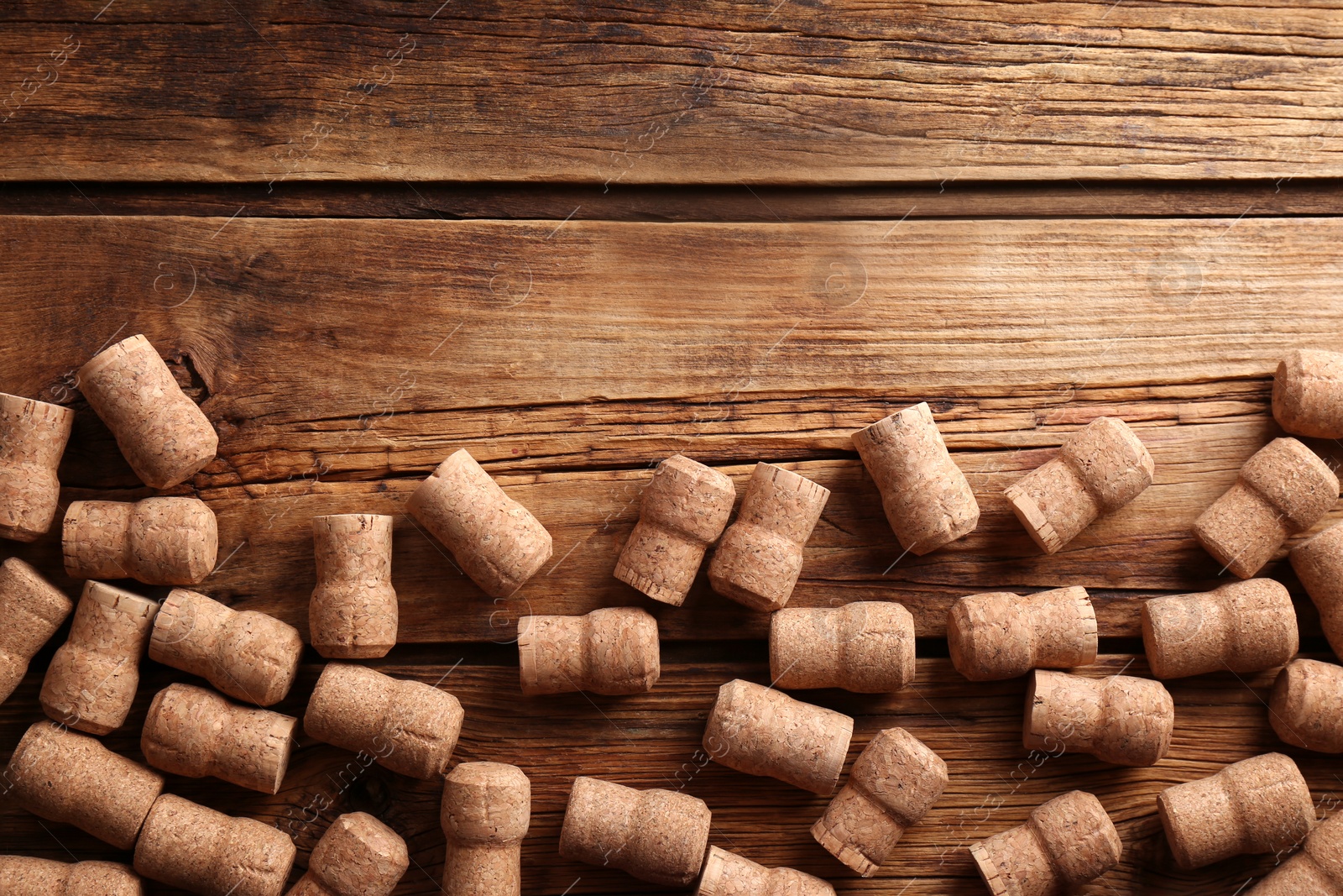 Photo of Sparkling wine bottle corks on wooden table, flat lay. Space for text