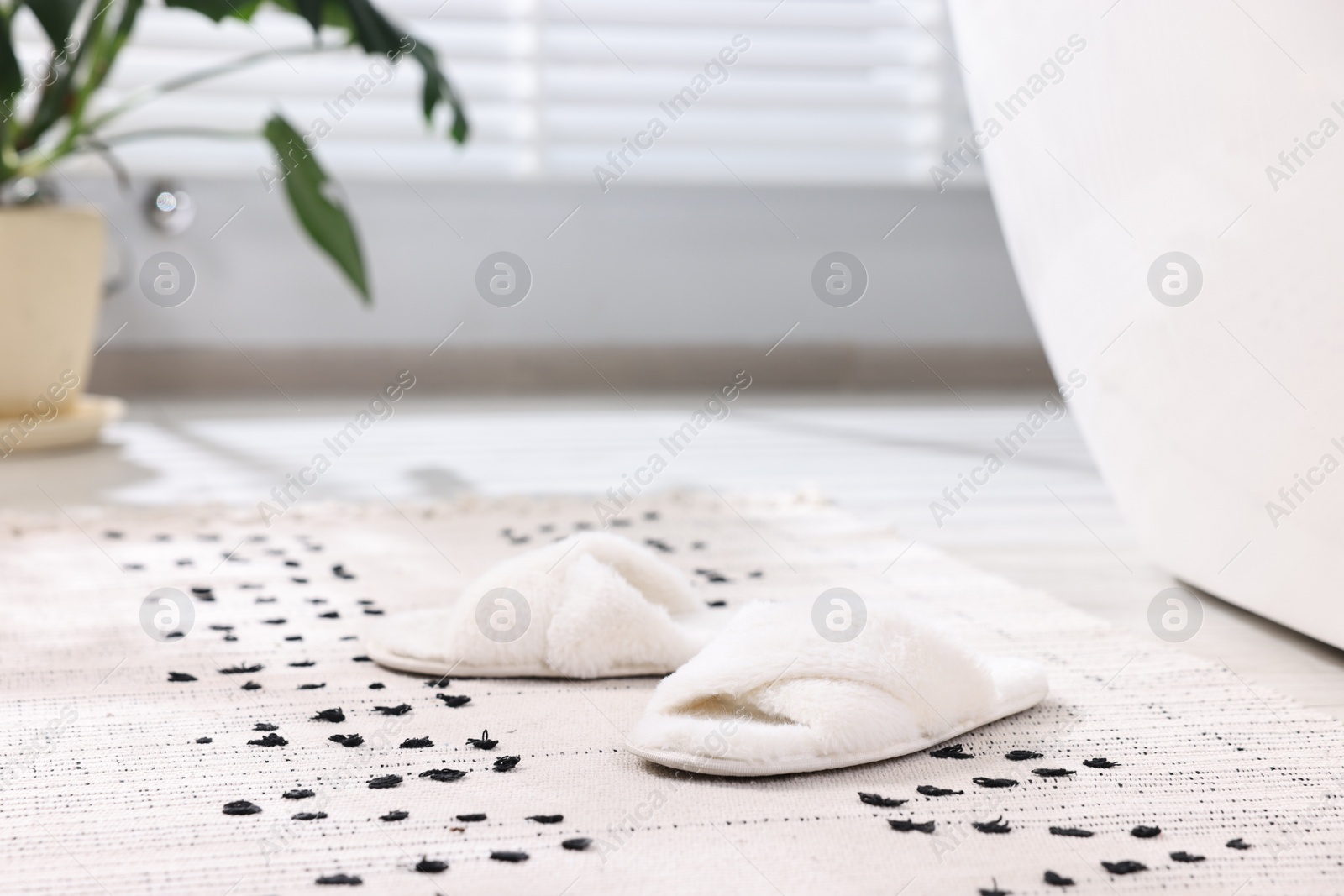 Photo of White soft slippers on carpet at home