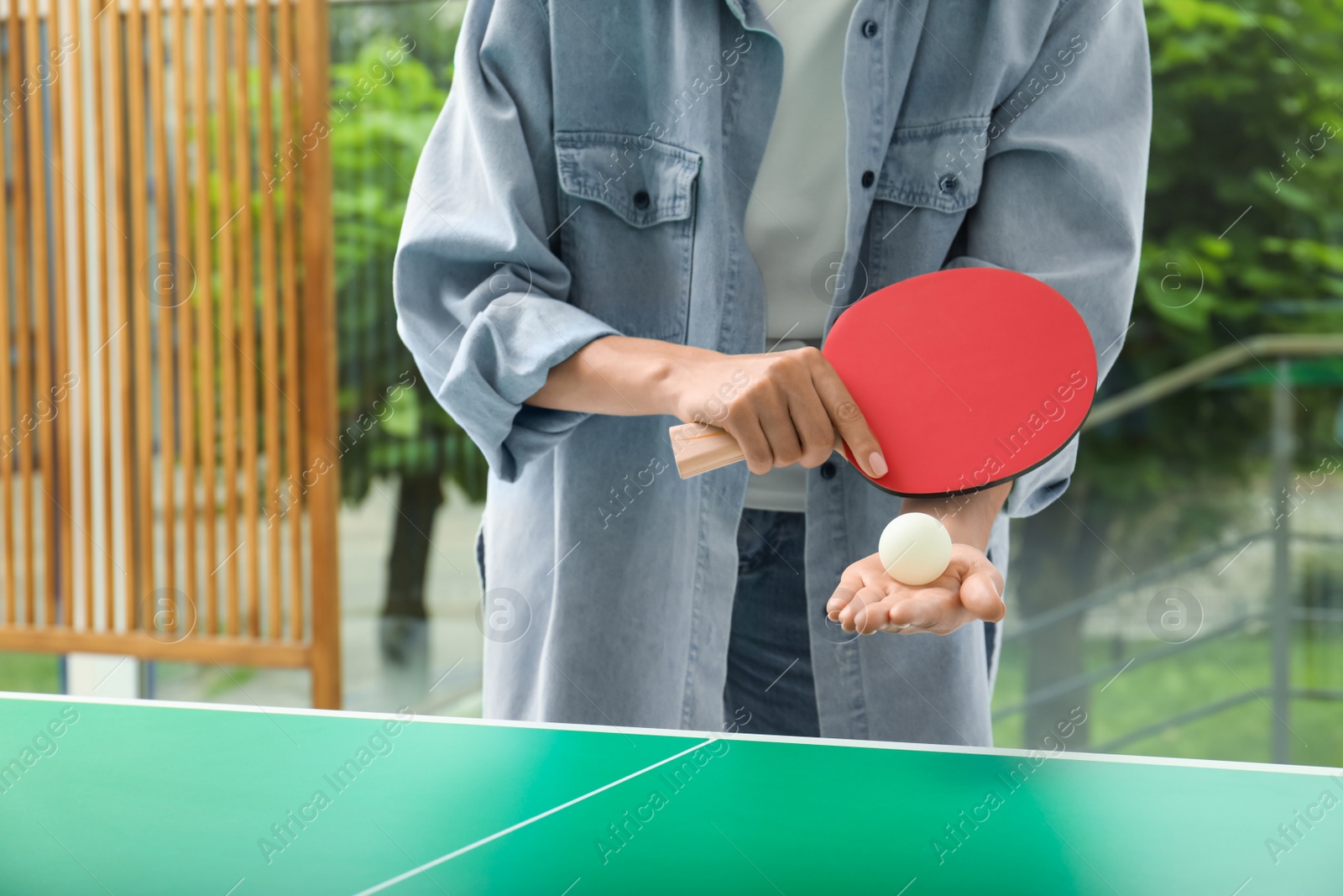 Photo of Woman playing ping pong indoors, closeup view