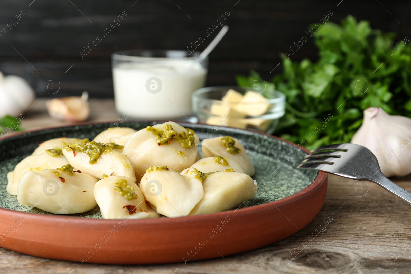 Photo of Delicious cooked dumplings with sauce on wooden table