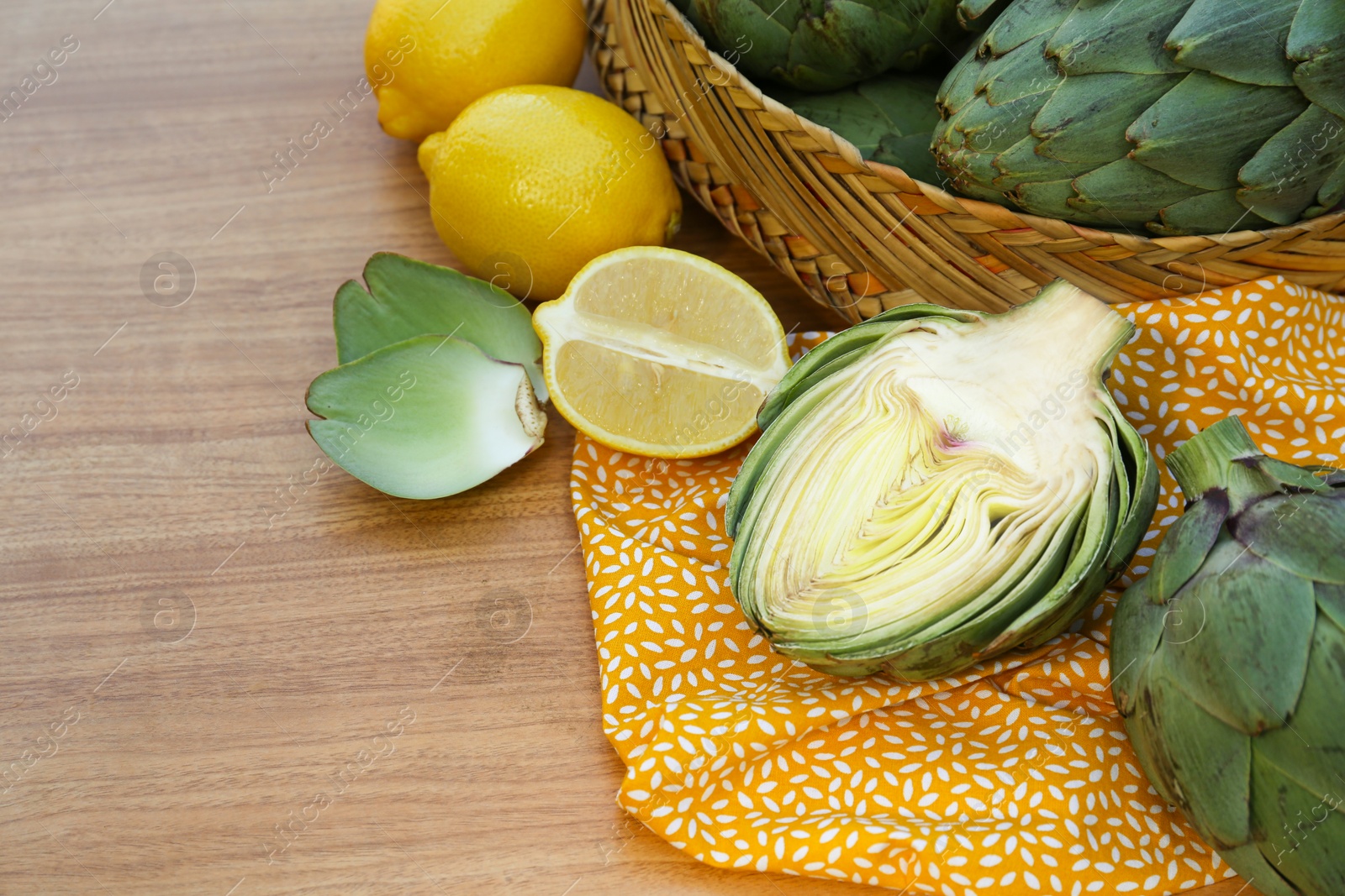 Photo of Tasty artichokes and lemons on wooden table