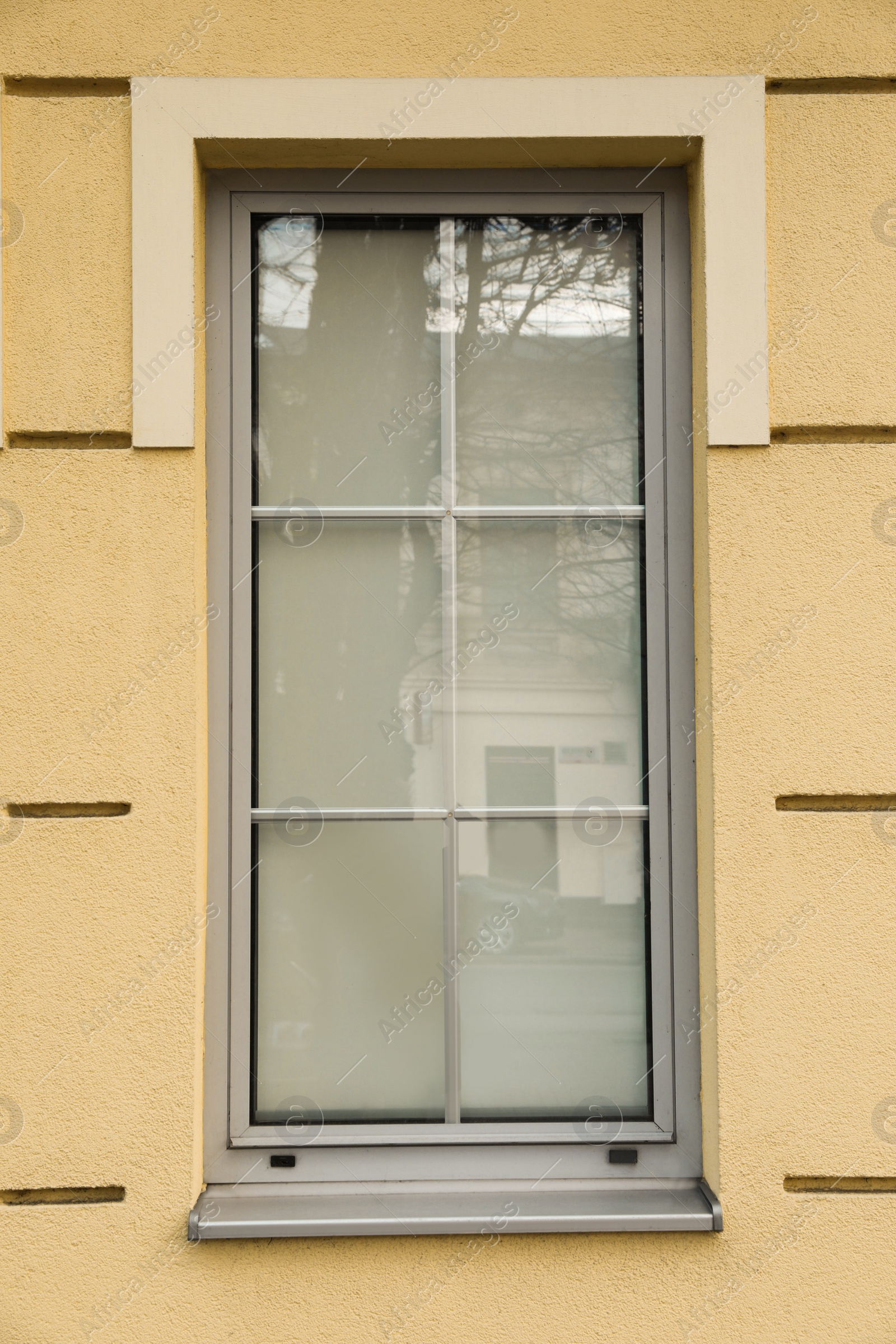 Photo of Yellow wall of building with stylish grey window