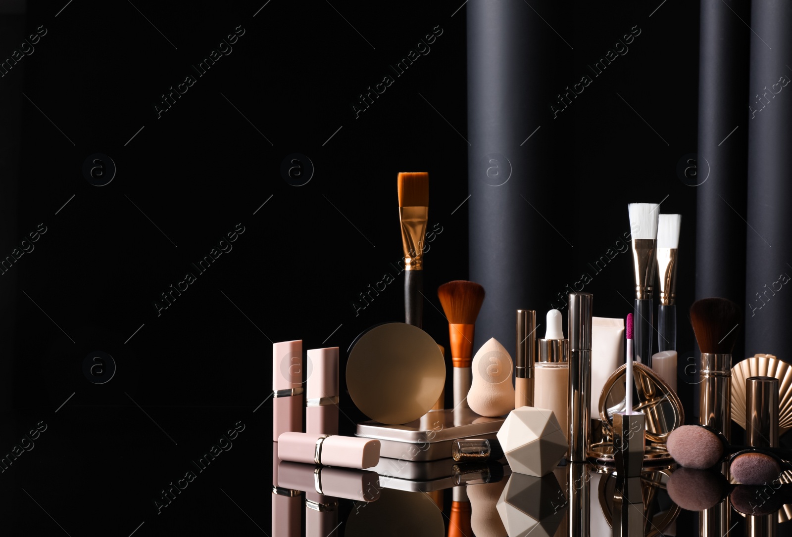 Photo of Composition with makeup products on table against black background