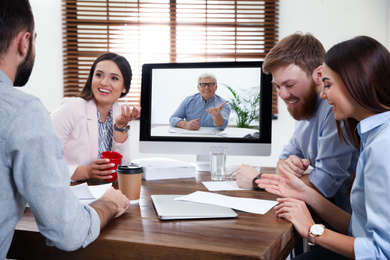 Image of Group of colleagues using video chat for online job interview in office 