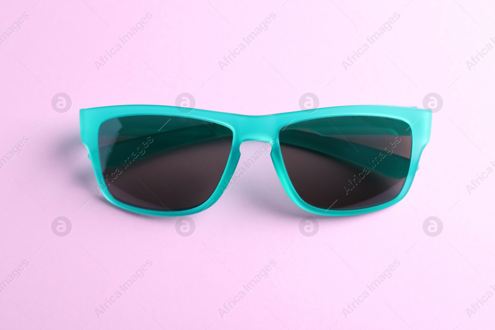 Photo of Stylish sunglasses on light violet background. Summer accessory