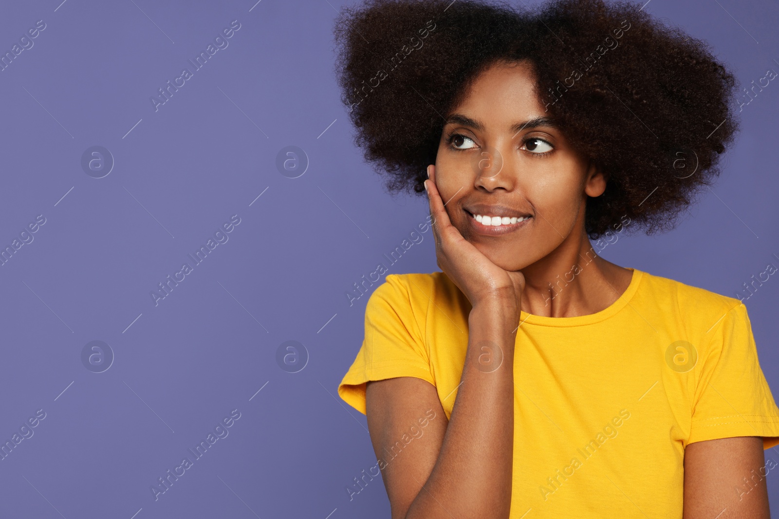 Photo of Portrait of smiling African American woman on purple background. Space for text