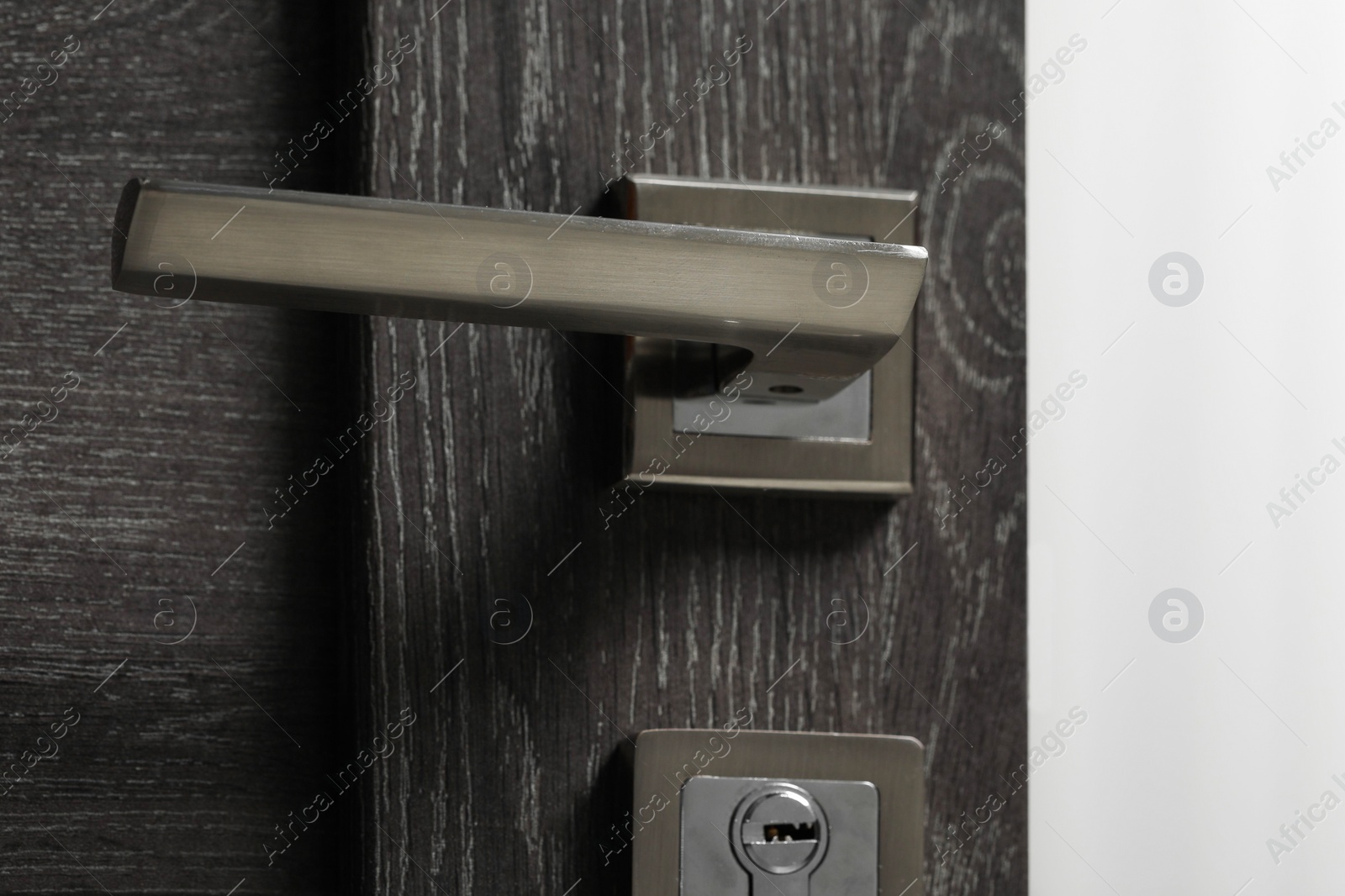 Photo of Open wooden door with metal handle, closeup