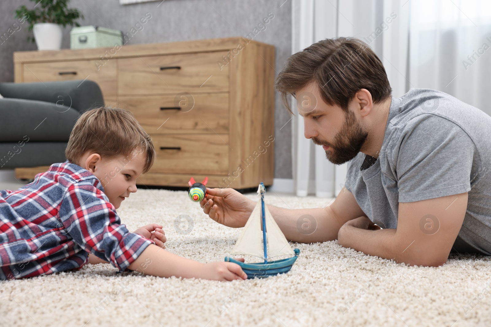 Photo of Dad and son playing toys together at home