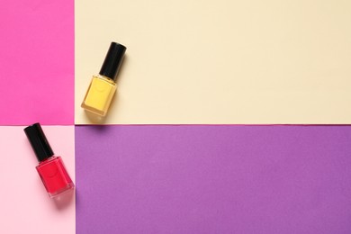 Photo of Nail polishes on color background, flat lay. Space for text