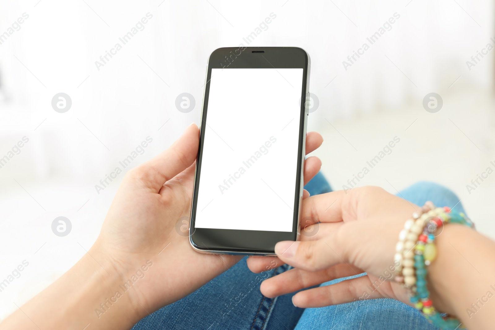 Photo of Woman holding smartphone with blank screen on light background. Mockup for design