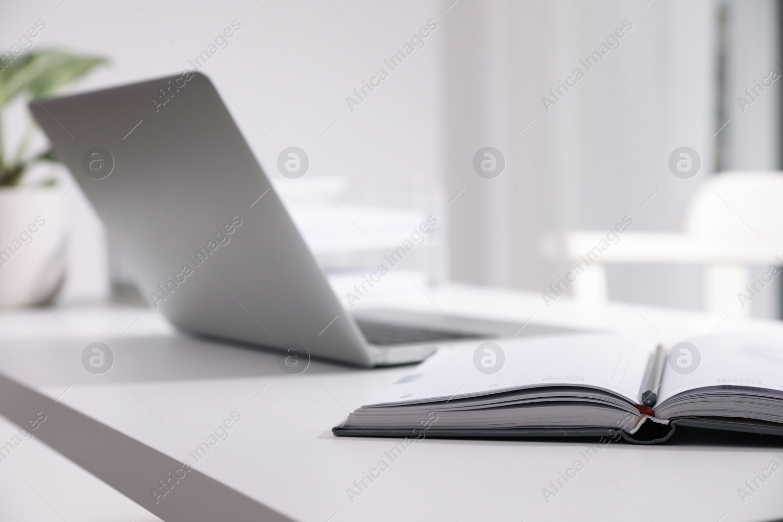 Photo of Comfortable workplace with open notebook in office, closeup