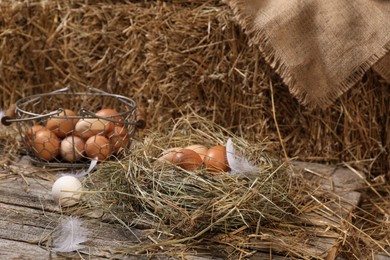 Photo of Fresh chicken eggs and dried straw bale in henhouse