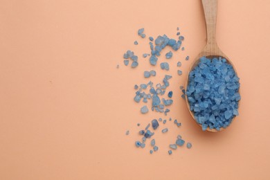 Photo of Spoon with blue sea salt on beige background, top view. Space for text