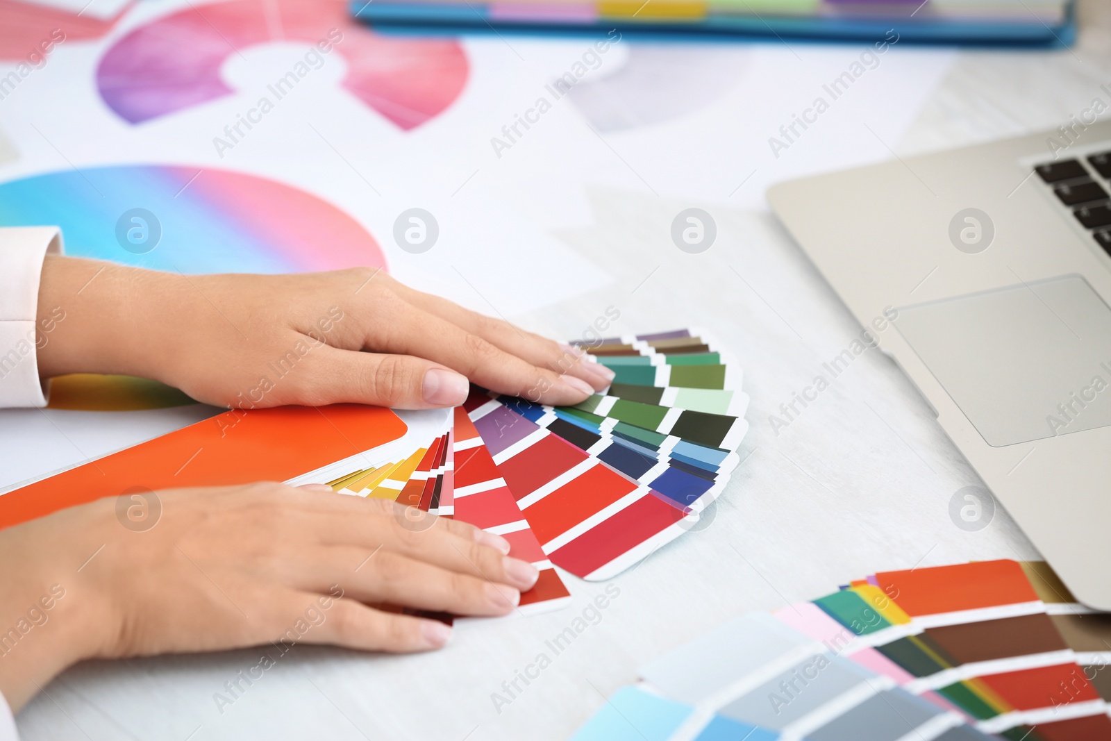 Photo of Woman with paint color palette samples at table, closeup