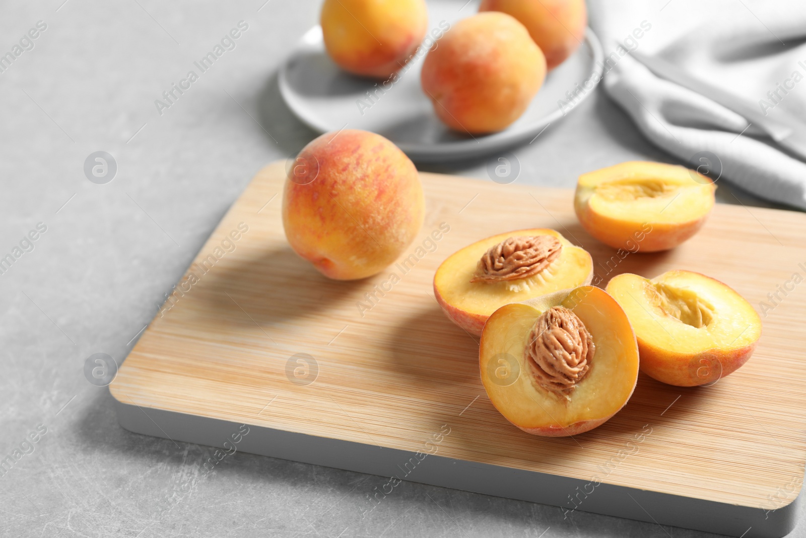 Photo of Wooden board with fresh sweet peaches on table, closeup