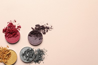 Photo of Different crushed eye shadows on beige background, flat lay. Space for text
