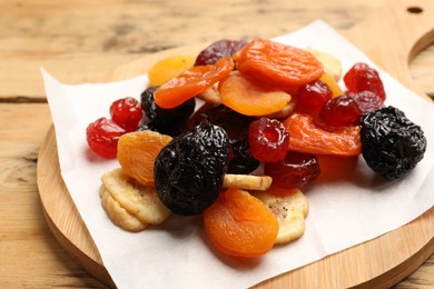 Photo of Mix of delicious dried fruits on wooden table, closeup