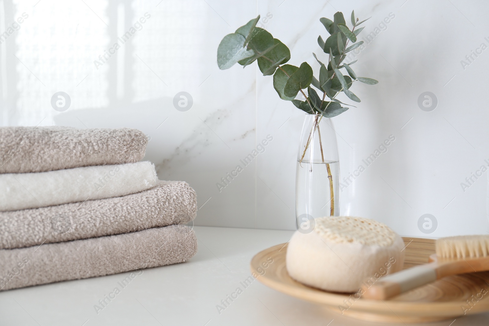 Photo of Fresh eucalyptus branches and bathroom items on countertop