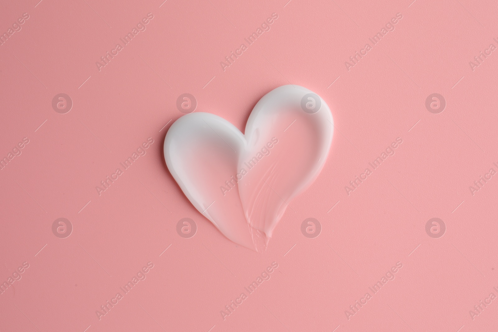 Photo of Sample facial cream on pale pink background, top view