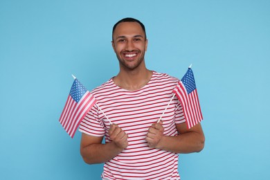 4th of July - Independence Day of USA. Happy man with American flags on light blue background