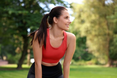 Photo of Portrait of smiling woman wearing sportswear in park