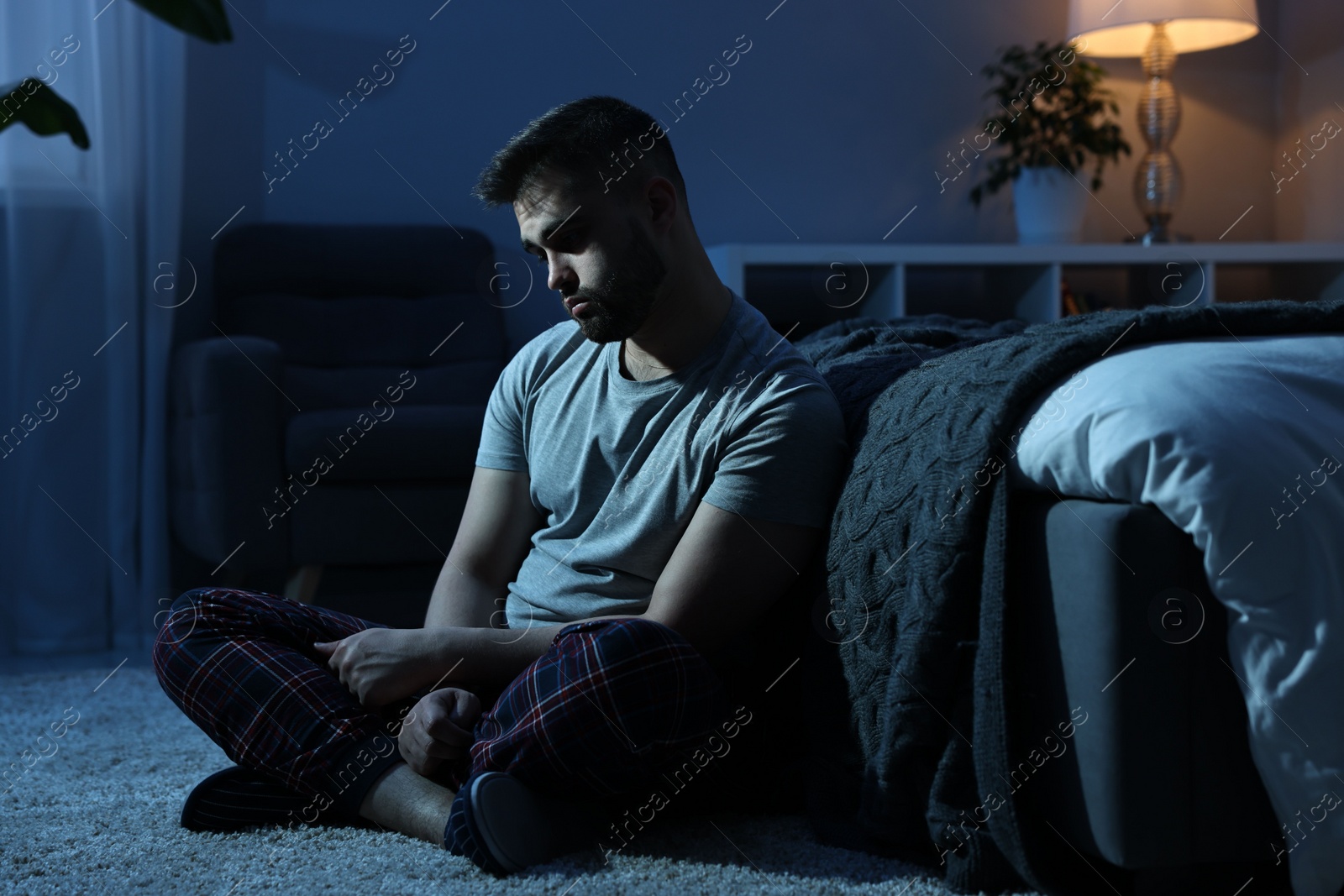 Photo of Frustrated man suffering from insomnia in bedroom at night