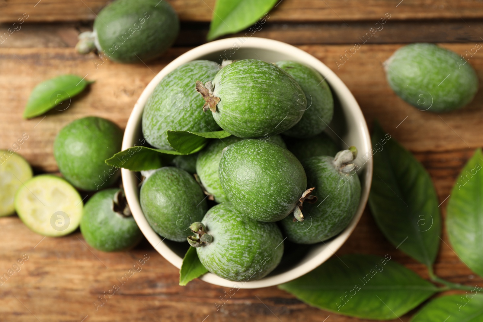 Photo of Flat lay composition with fresh green feijoa fruits on wooden table