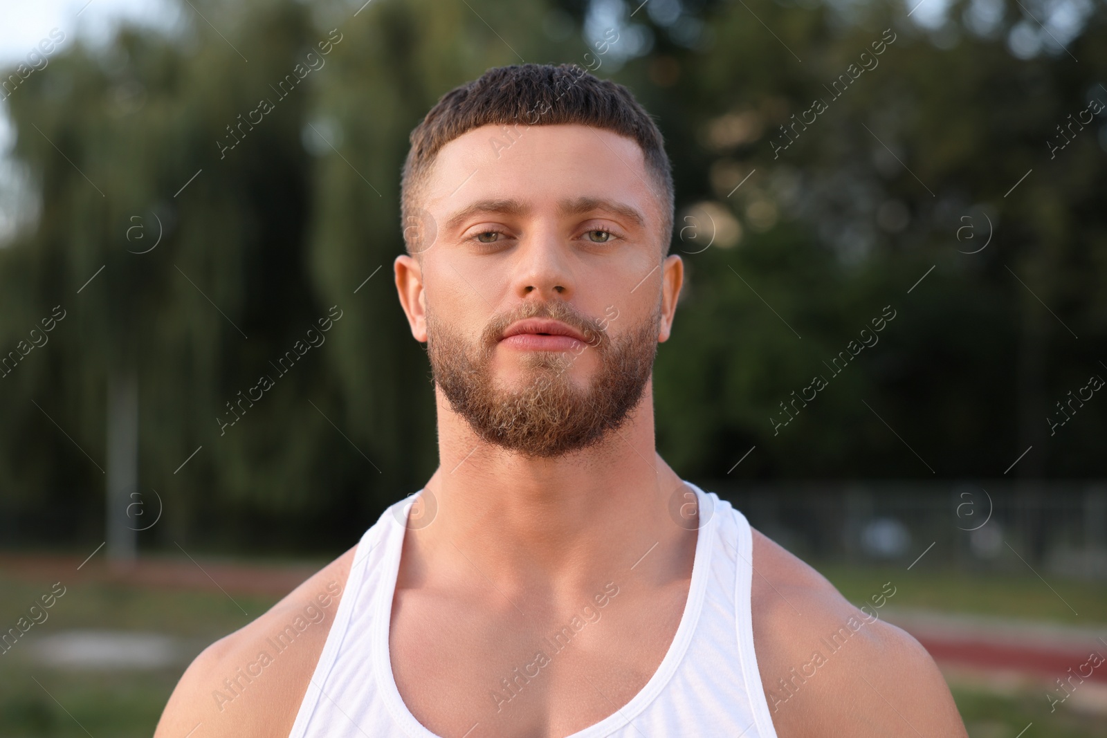 Photo of Portrait of attractive young man outdoors on summer day