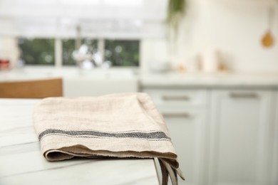 Photo of Clean towel on white marble table in kitchen. Space for text