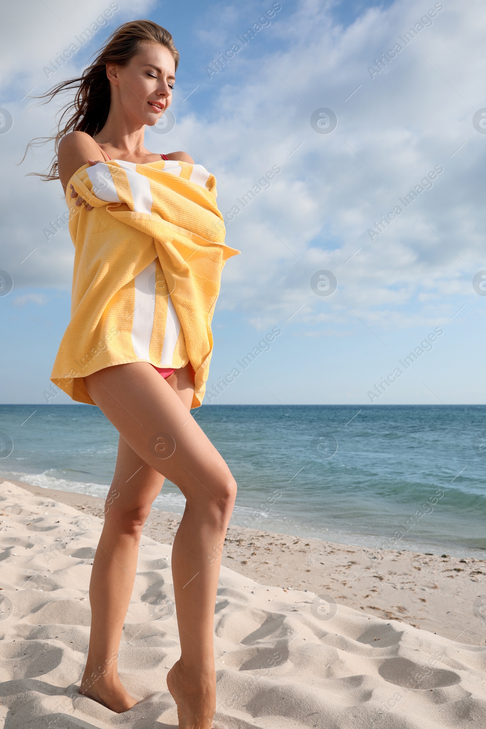 Photo of Beautiful woman with beach towel near sea