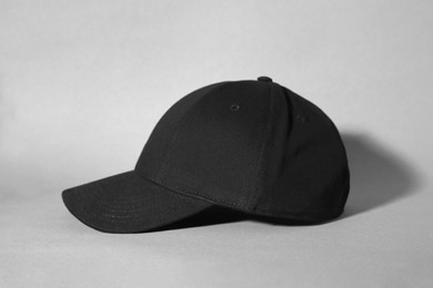 Photo of Stylish black baseball cap on grey background