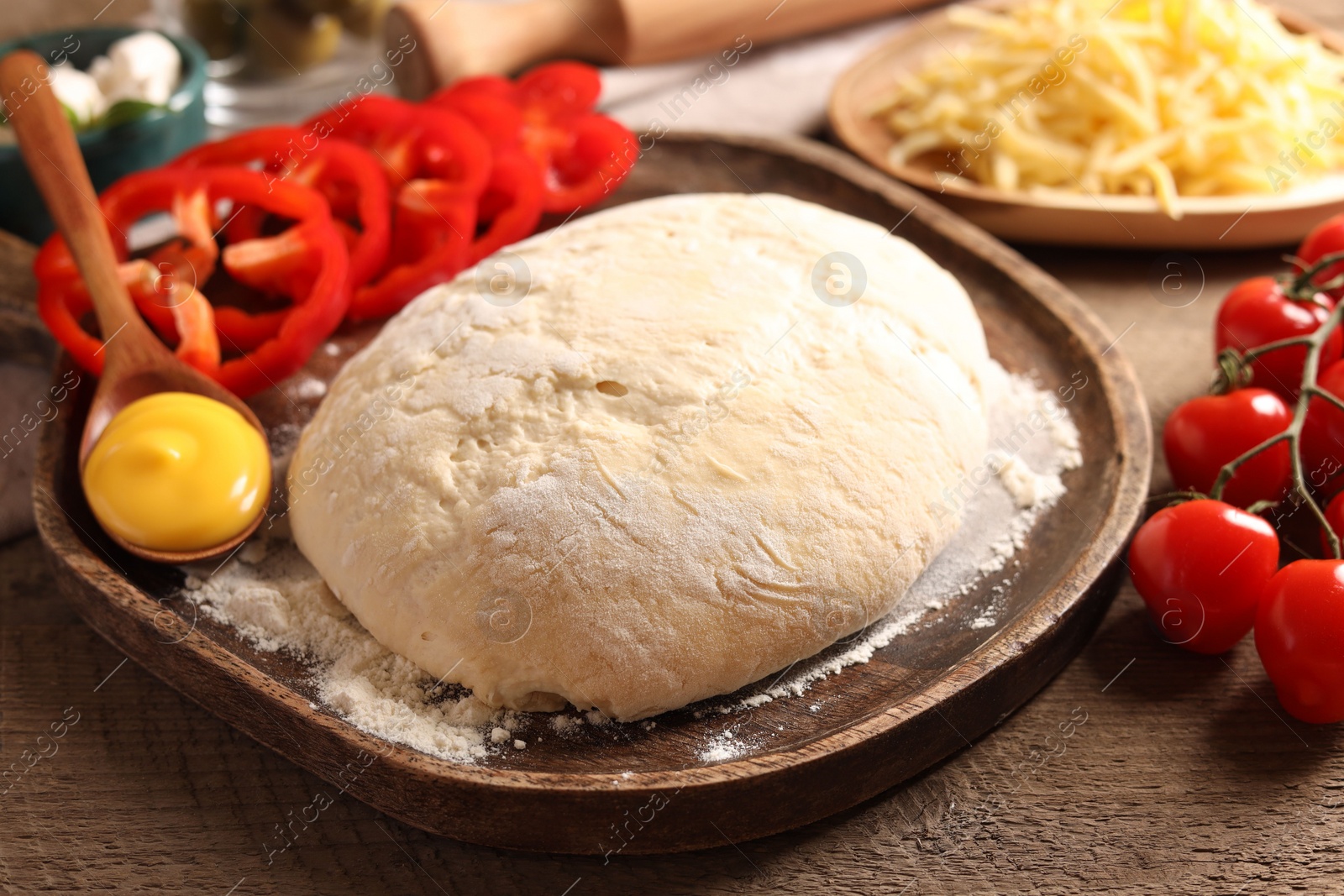 Photo of Pizza dough and products on wooden table, closeup