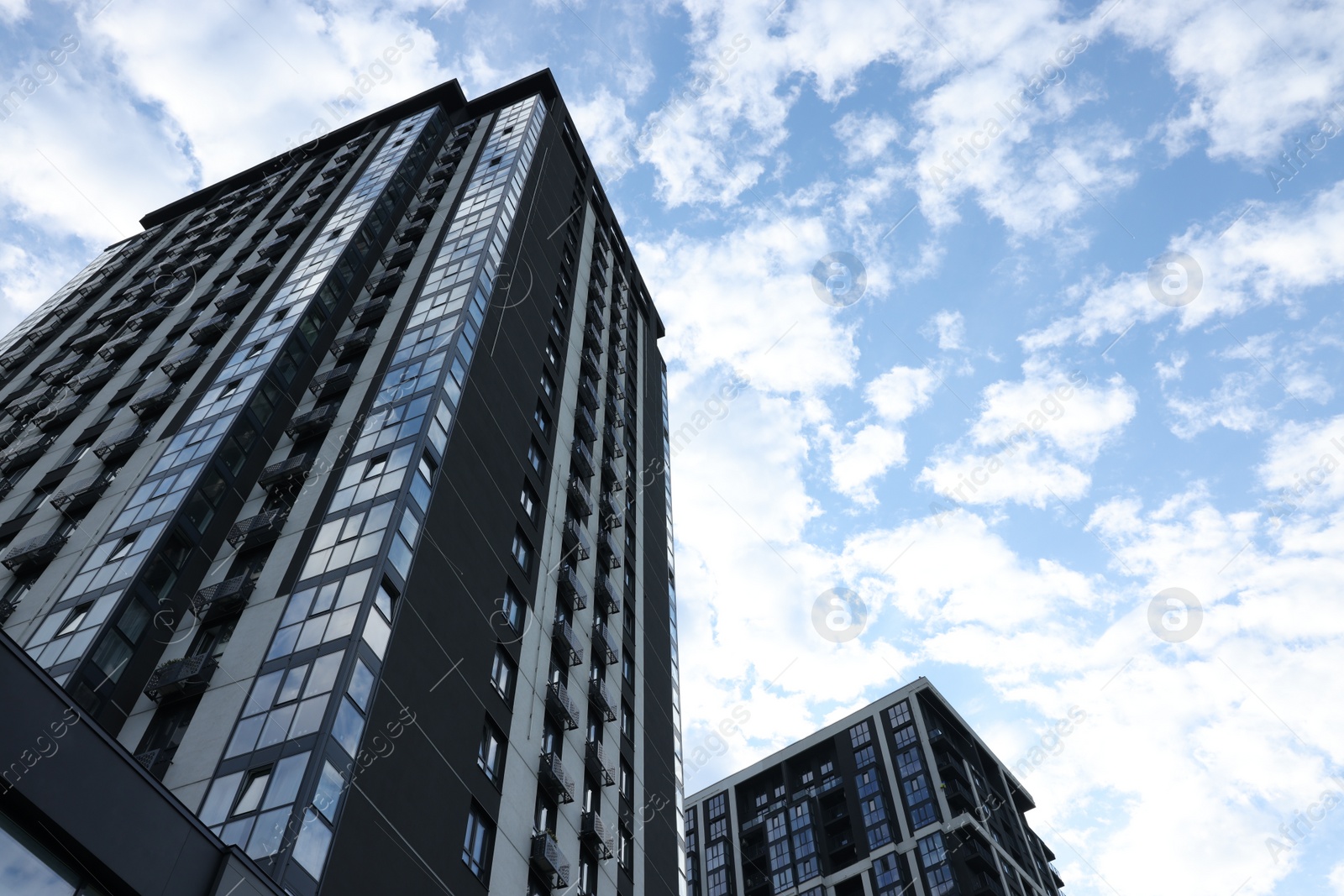 Photo of Modern skyscrapers against cloudy sky, low angle view