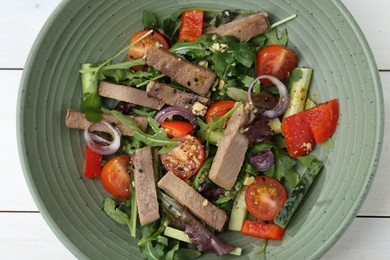 Delicious salad with beef tongue and vegetables on white wooden table, top view