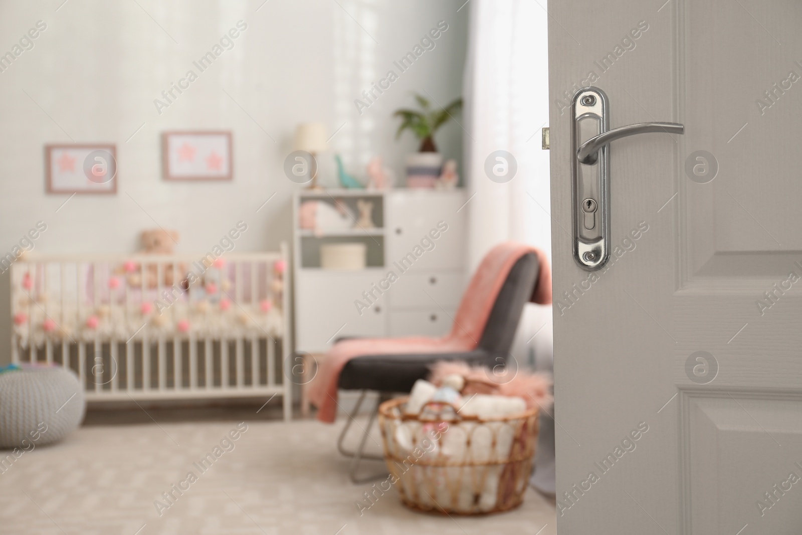 Photo of Blurred view of baby room interior  with comfortable crib