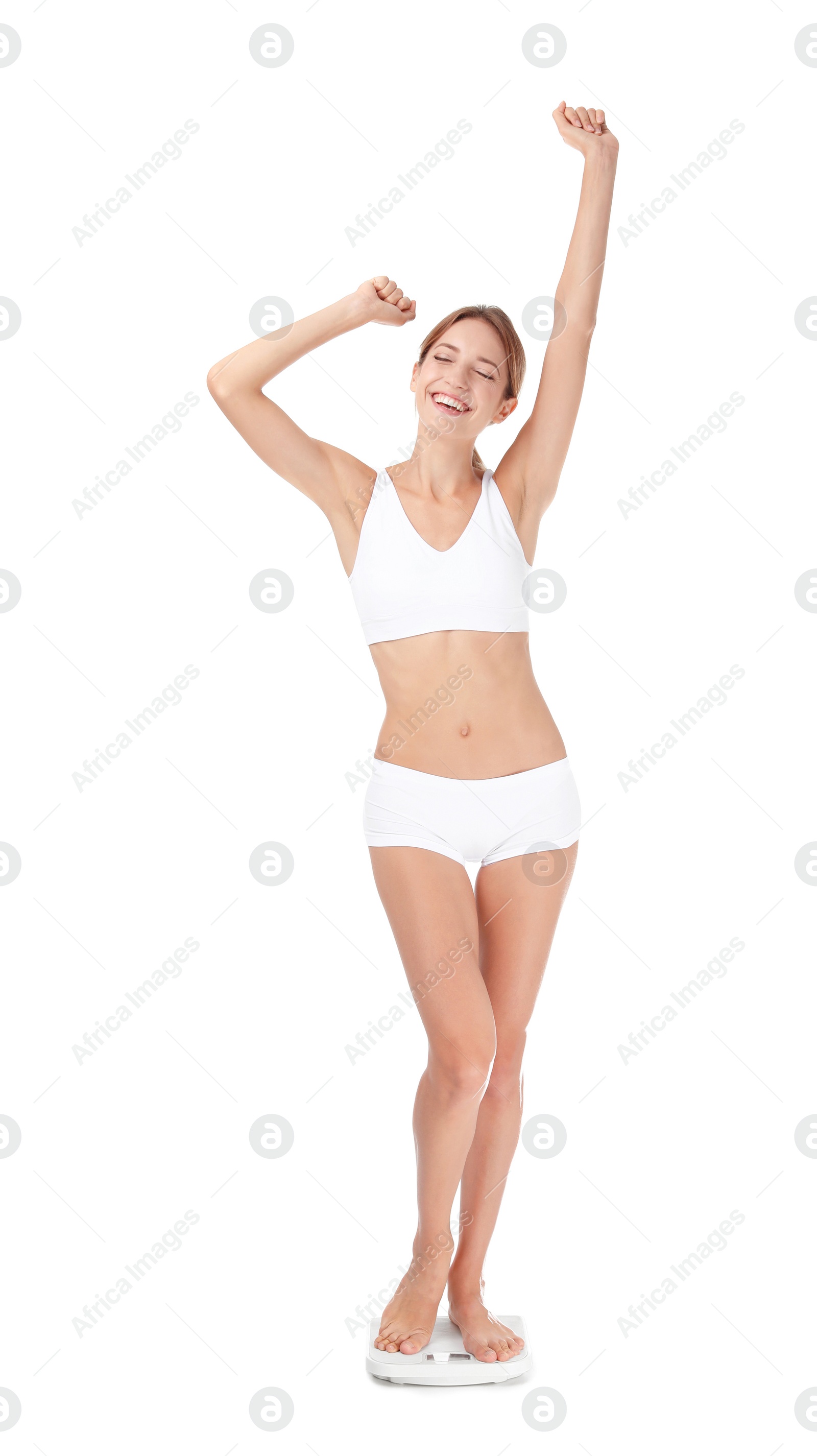 Photo of Happy young woman satisfied with her diet results using bathroom scales on white background