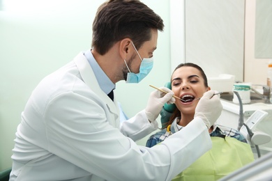 Professional dentist working with patient in modern clinic