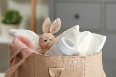 Photo of Mother's bag with baby's stuff indoors, closeup