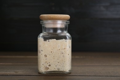 Leaven in glass jar on wooden table