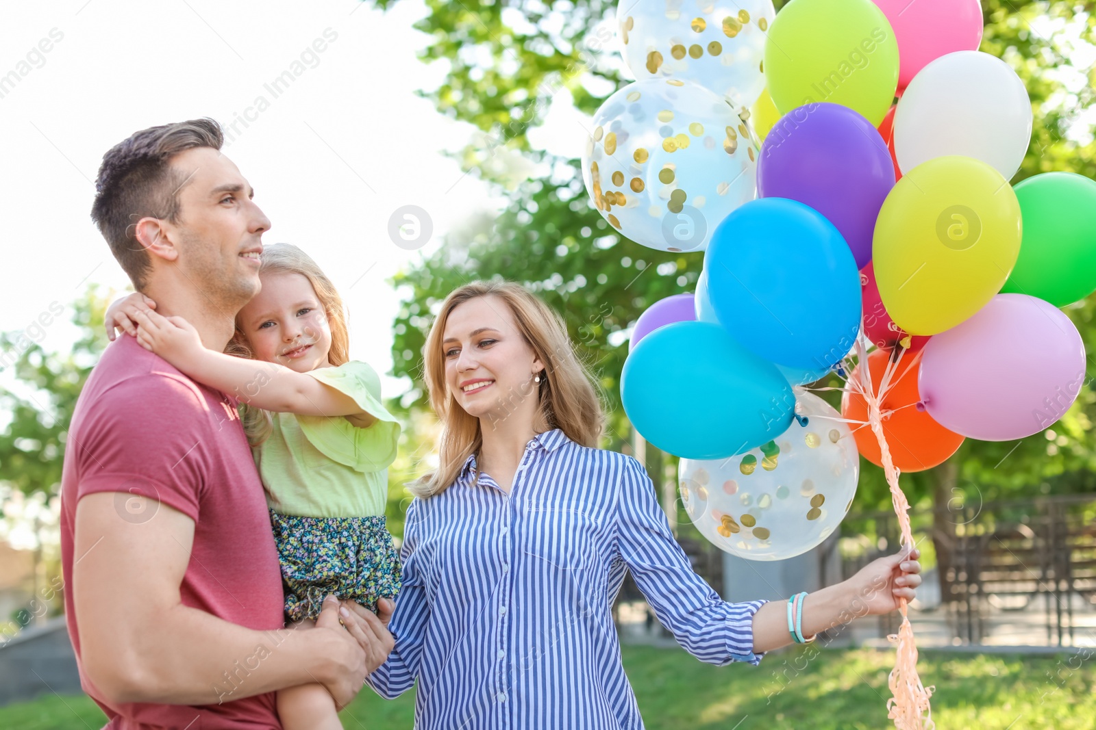 Photo of Happy family with colorful balloons outdoors on sunny day