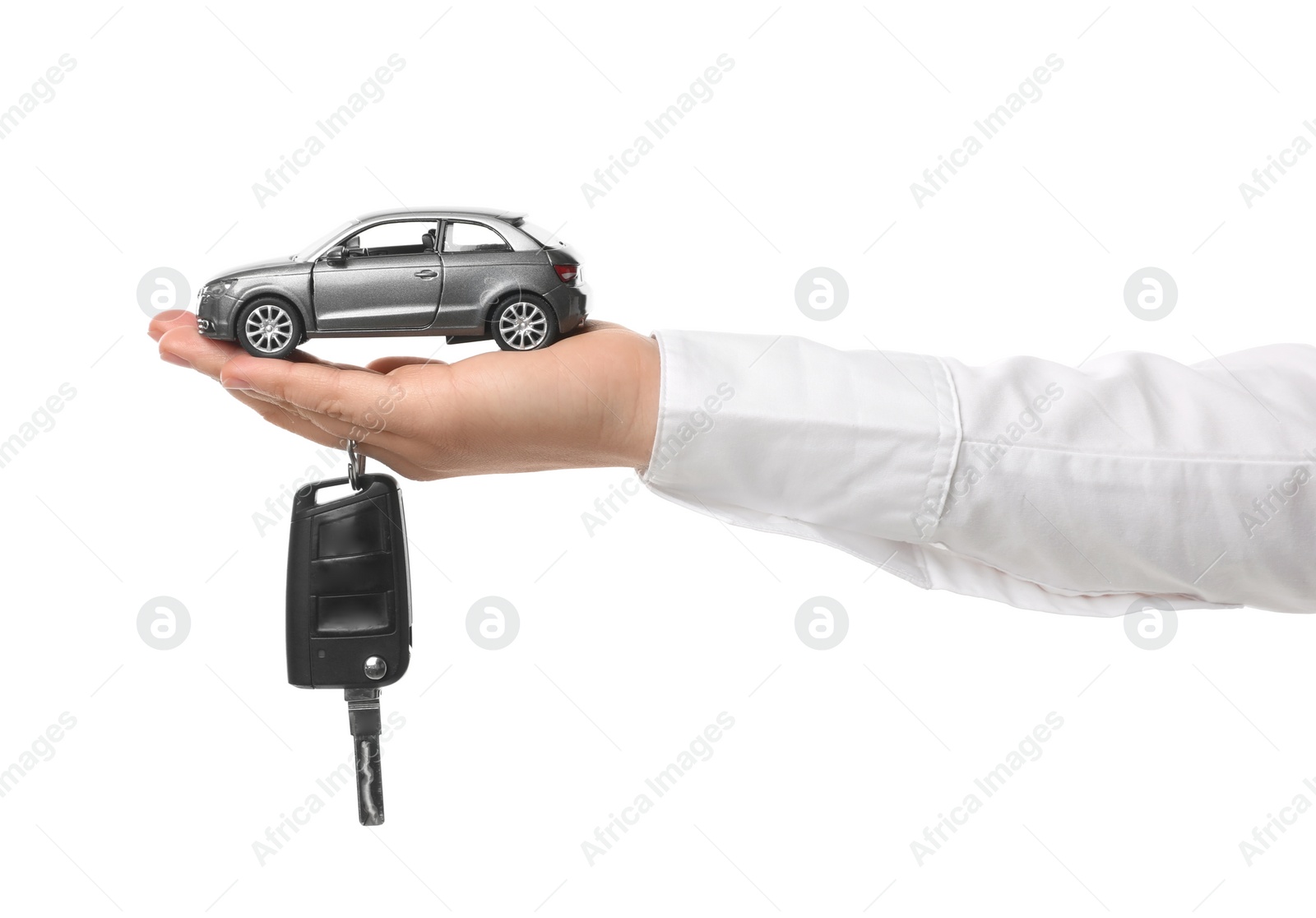 Photo of Man holding key and miniature automobile model on white background, closeup. Car buying