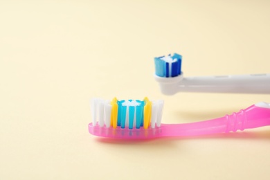 Photo of Manual and electric toothbrushes on color background. Dental care