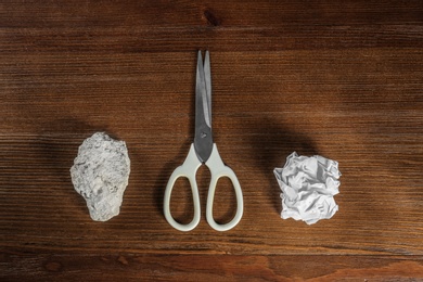 Flat lay composition with rock, paper and scissors on wooden background