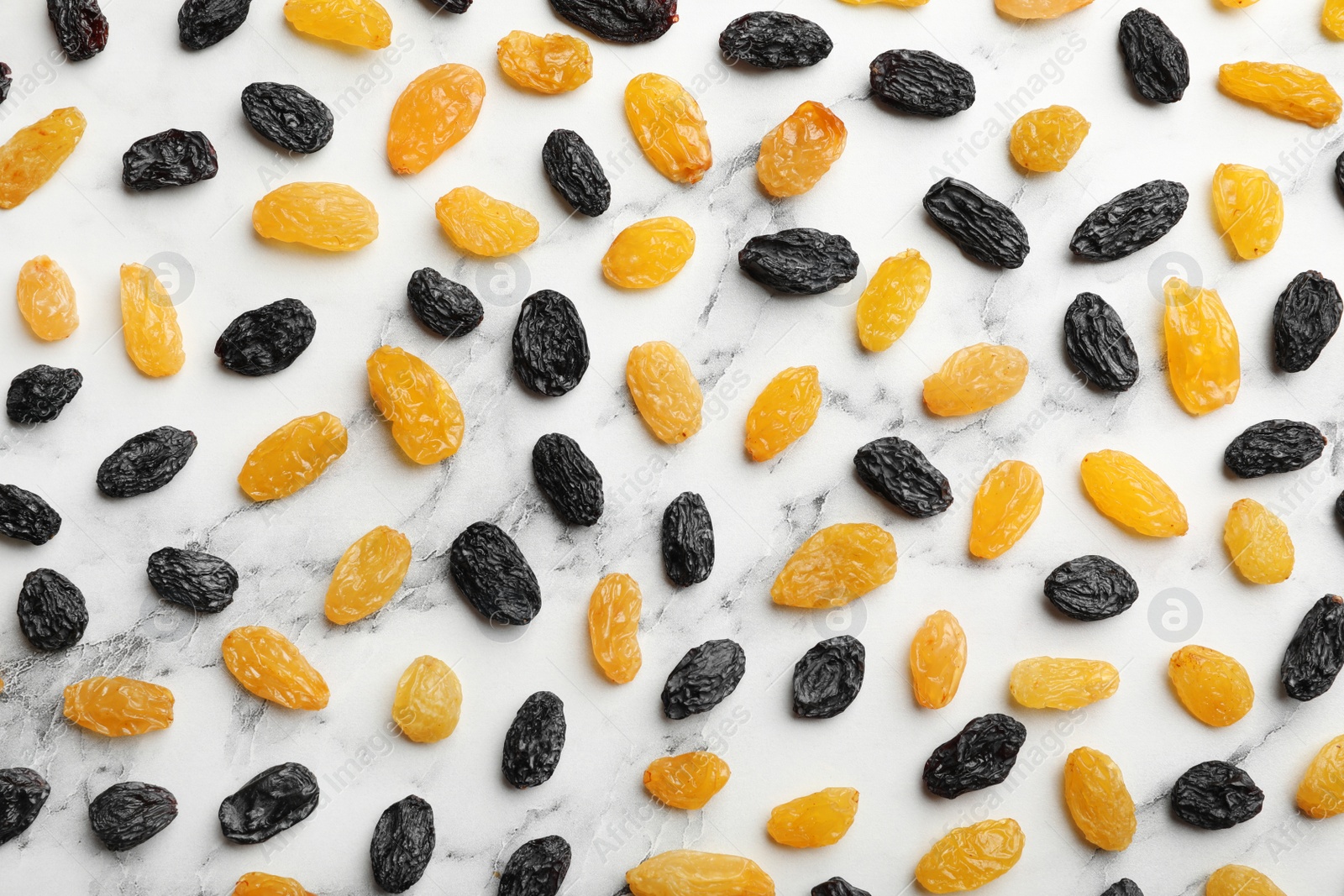 Photo of Flat lay composition with raisins on marble background. Dried fruit as healthy snack